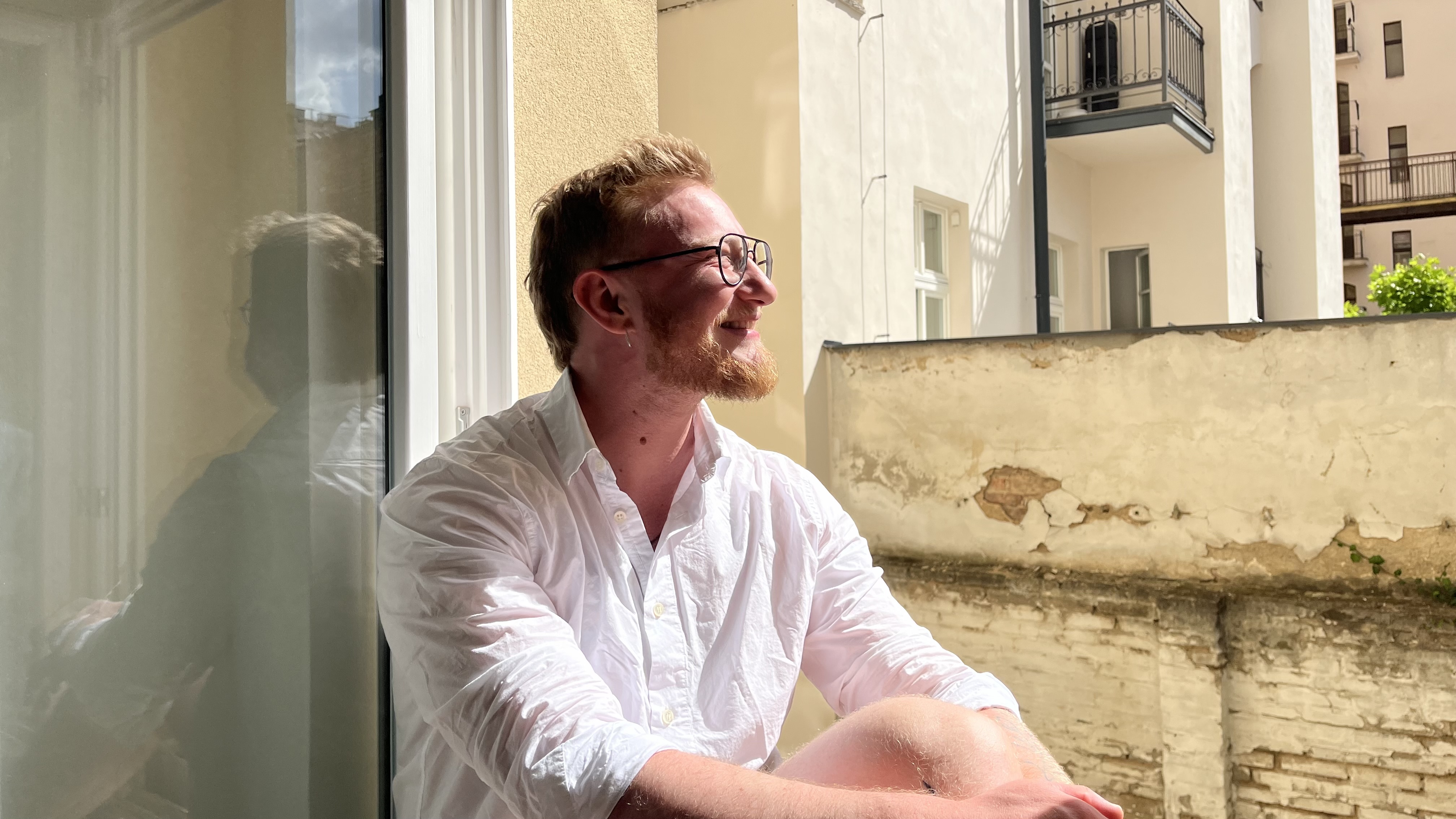 Jan Vacha smiling, sitting by a window in natural light